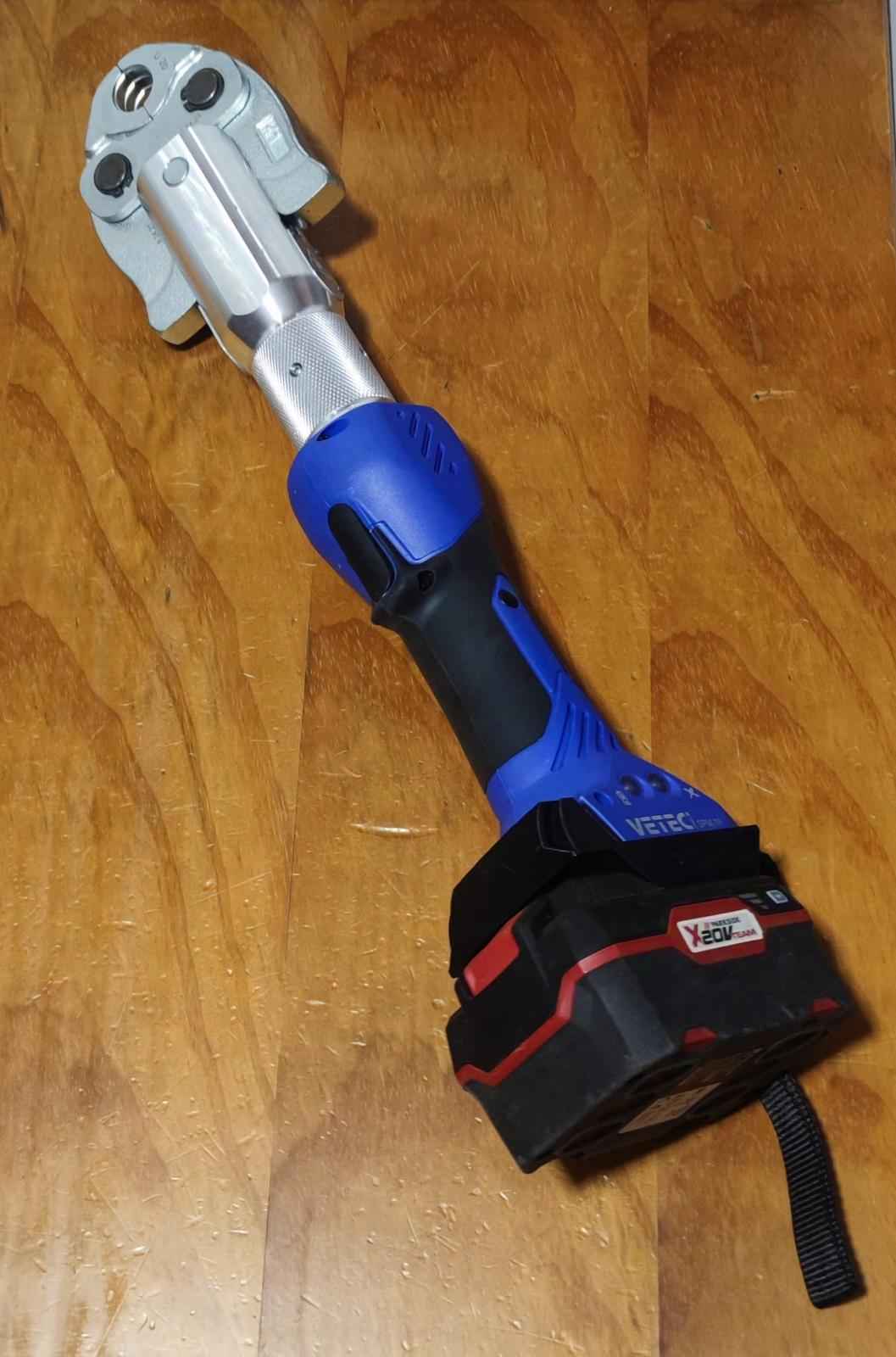 Herramienta eléctrica a batería con mango azul y negro sobre mesa de madera, Miartesaniaen3D